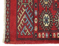 A vintage Pakistani Princess Bokhara rug featuring a geometric red pattern with wool pile.