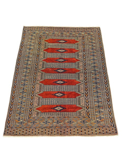 A vintage Pakistani Princess Bokhara rug featuring a repeating red diamond pattern on a wool pile.