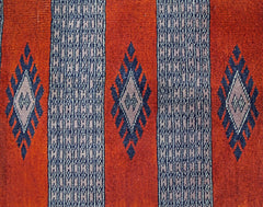 A vintage Pakistani Princess Bokhara rug featuring a repeating diamond pattern on a red background.
