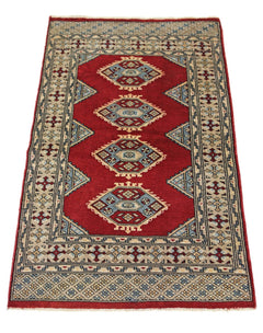 A vintage Pakistani Princess Bokhara rug featuring four geometric medallions on a red field.