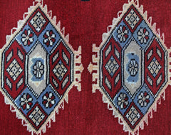 A vintage Pakistani Princess Bokhara rug featuring repeating geometric diamond motifs in red and blue.