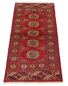 A vintage Pakistani Princess Bokhara rug featuring a red field with repeating geometric motifs.