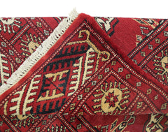 A vintage Pakistani Princess Bokhara rug featuring a red geometric pattern and white fringe.
