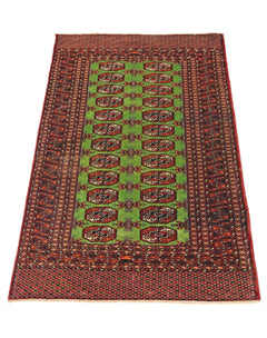 A vintage Pakistani Princess Bokhara rug featuring a green field with repeating geometric motifs.