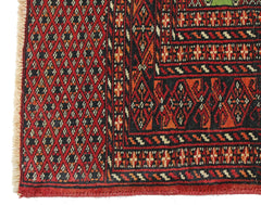 A vintage Pakistani Princess Bokhara rug featuring a geometric diamond pattern in red and black.