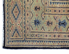 A vintage Pakistani Princess Bokhara rug featuring intricate geometric patterns in muted tones.