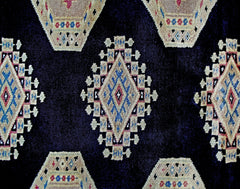 A vintage Pakistani Bokhara rug featuring a dark blue field with repeating geometric diamond motifs.