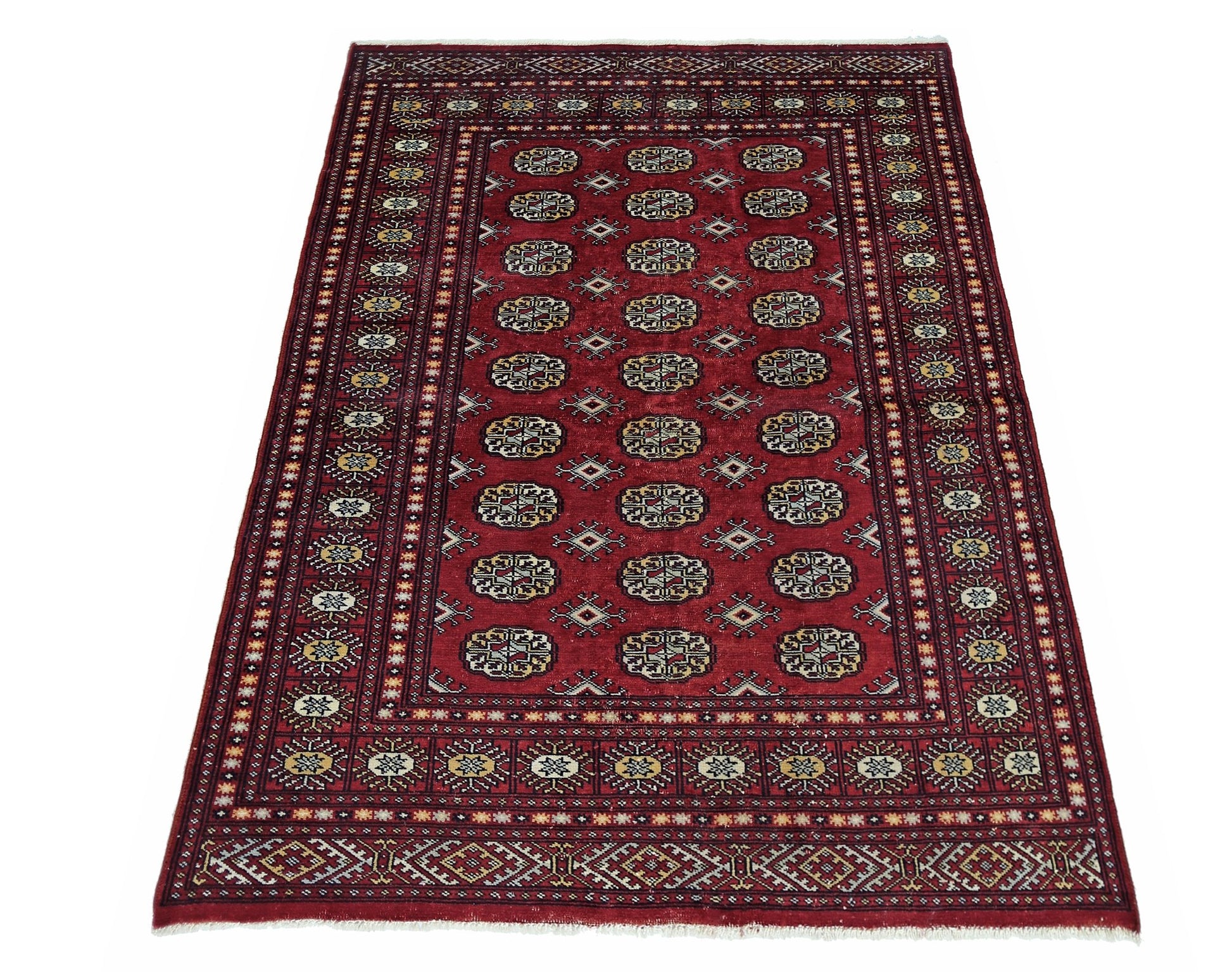 A vintage Pakistani Princess Bokhara rug featuring a repeating geometric pattern on a red field.