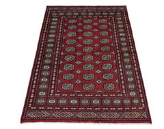 A vintage Pakistani Princess Bokhara rug featuring a repeating geometric pattern on a red field.