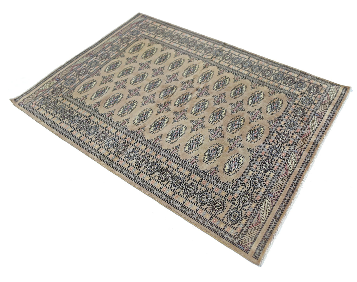 A vintage Pakistani Princess Bokhara rug featuring a repeating geometric pattern on a tan field.