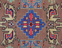 A vintage Pakistani Princess Bokhara rug featuring a geometric blue medallion on a brown field.