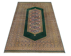 A vintage Pakistani Princess Bokhara rug featuring a deep green field with repeating geometric motifs.