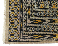 A vintage Pakistani Princess Bokhara rug featuring a geometric diamond pattern in black and gold.