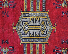 A vintage Pakistani Princess Bokhara rug featuring a central geometric medallion on a red field.