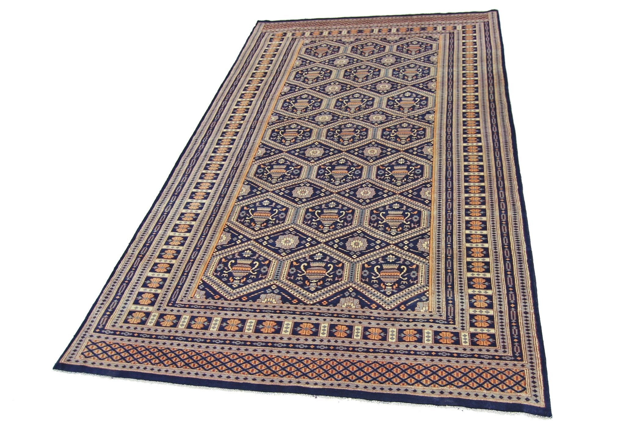 A vintage Pakistani Princess Bokhara rug featuring a dark blue field with repeating geometric motifs.