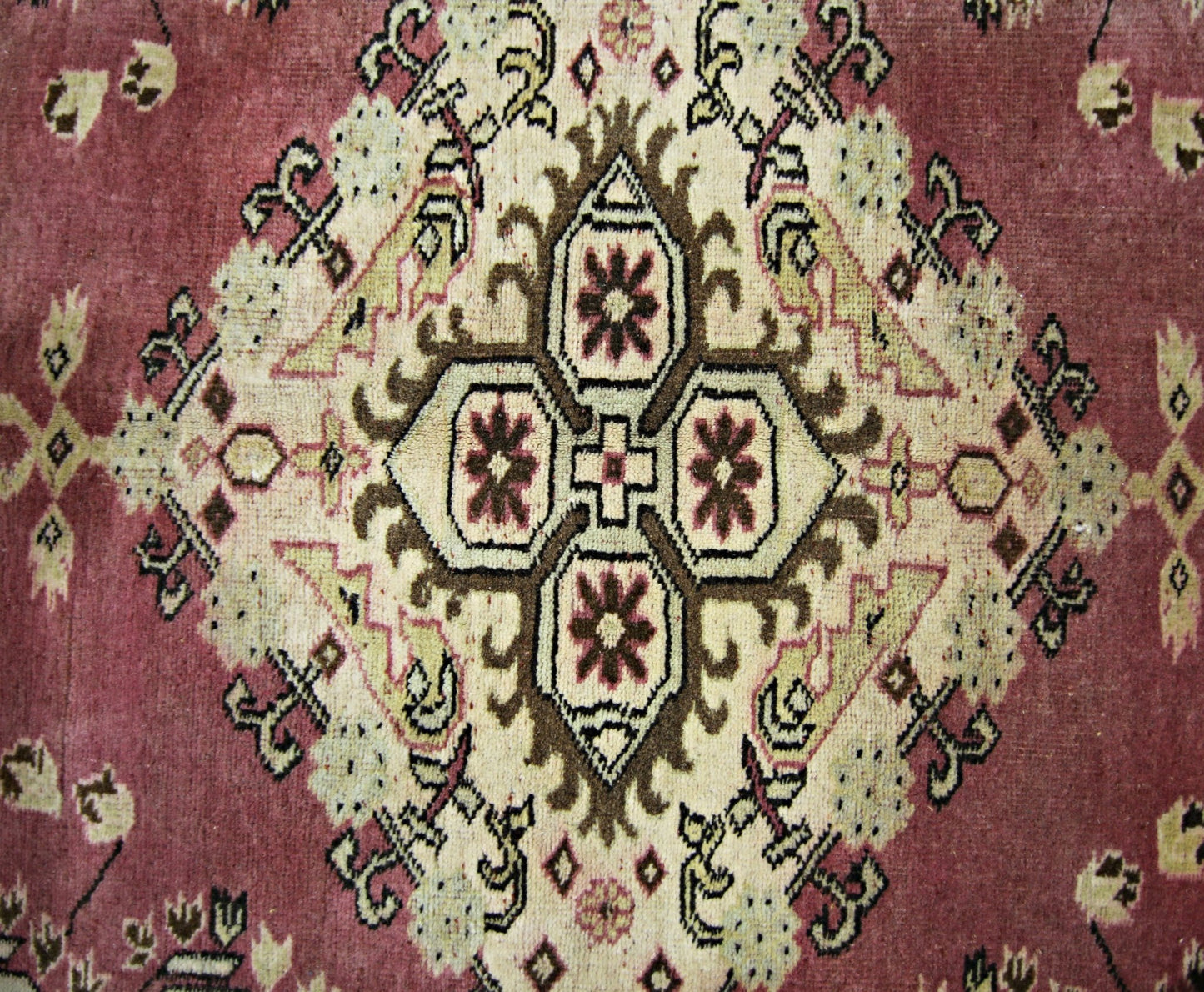 A vintage Pakistani Princess Bokhara rug featuring a central geometric medallion on a red field.