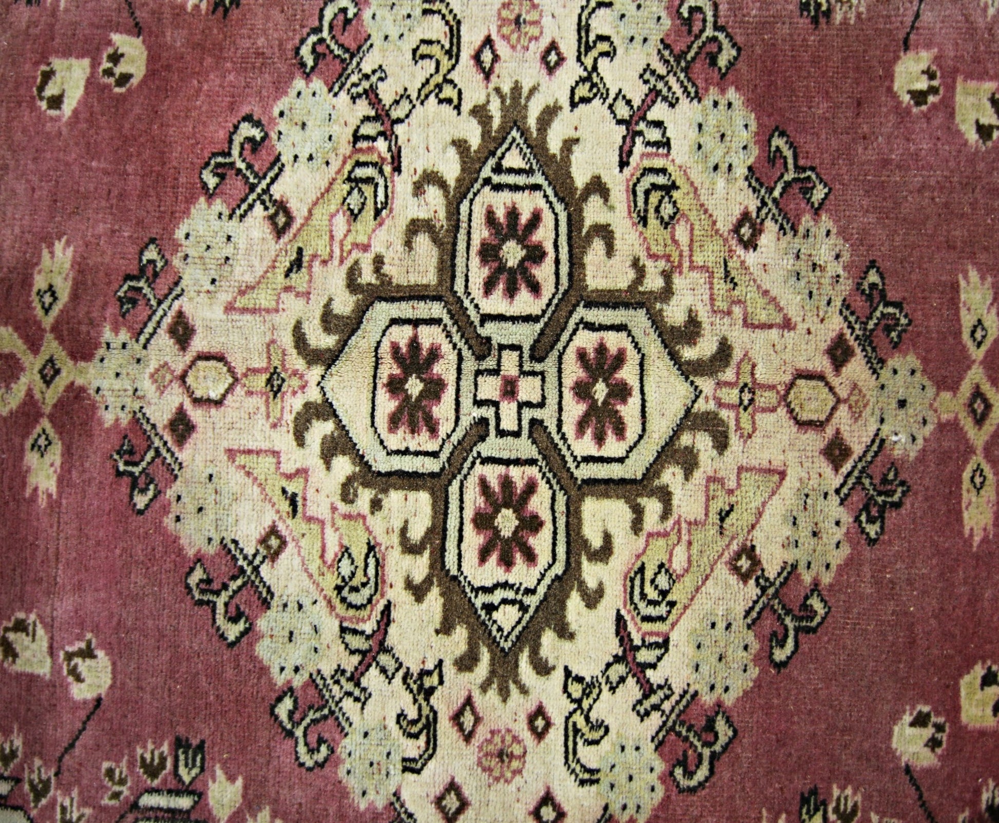 A vintage Pakistani Princess Bokhara rug featuring a central geometric medallion on a red field.