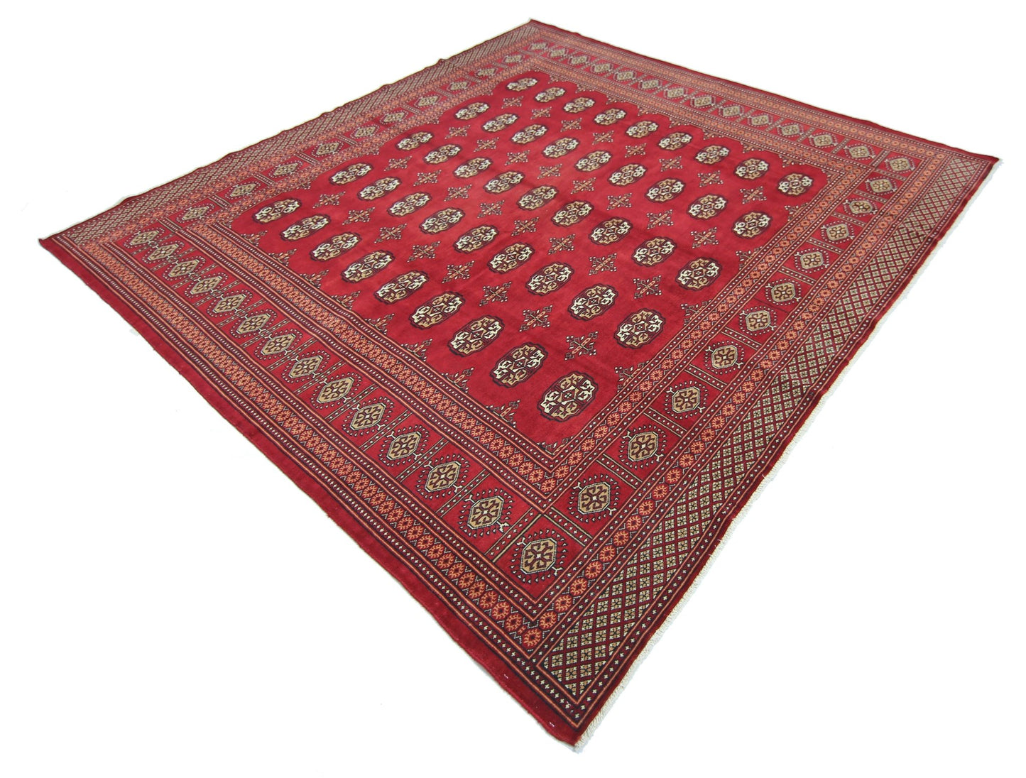 A vintage Pakistani Princess Bokhara rug featuring a repeating geometric pattern on a red field.