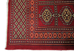 A vintage Pakistani Princess Bokhara rug featuring a geometric red pattern with cream accents.