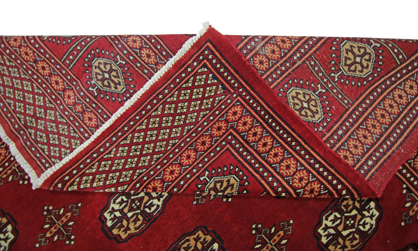 A vintage Pakistani Princess Bokhara rug featuring a deep red field with traditional geometric motifs.