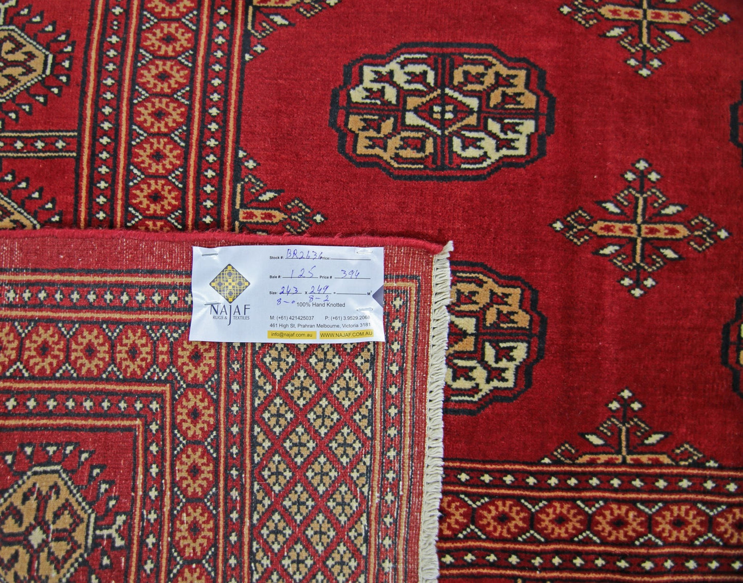 A vintage Pakistani Princess Bokhara rug featuring a deep red field with repeating geometric motifs.