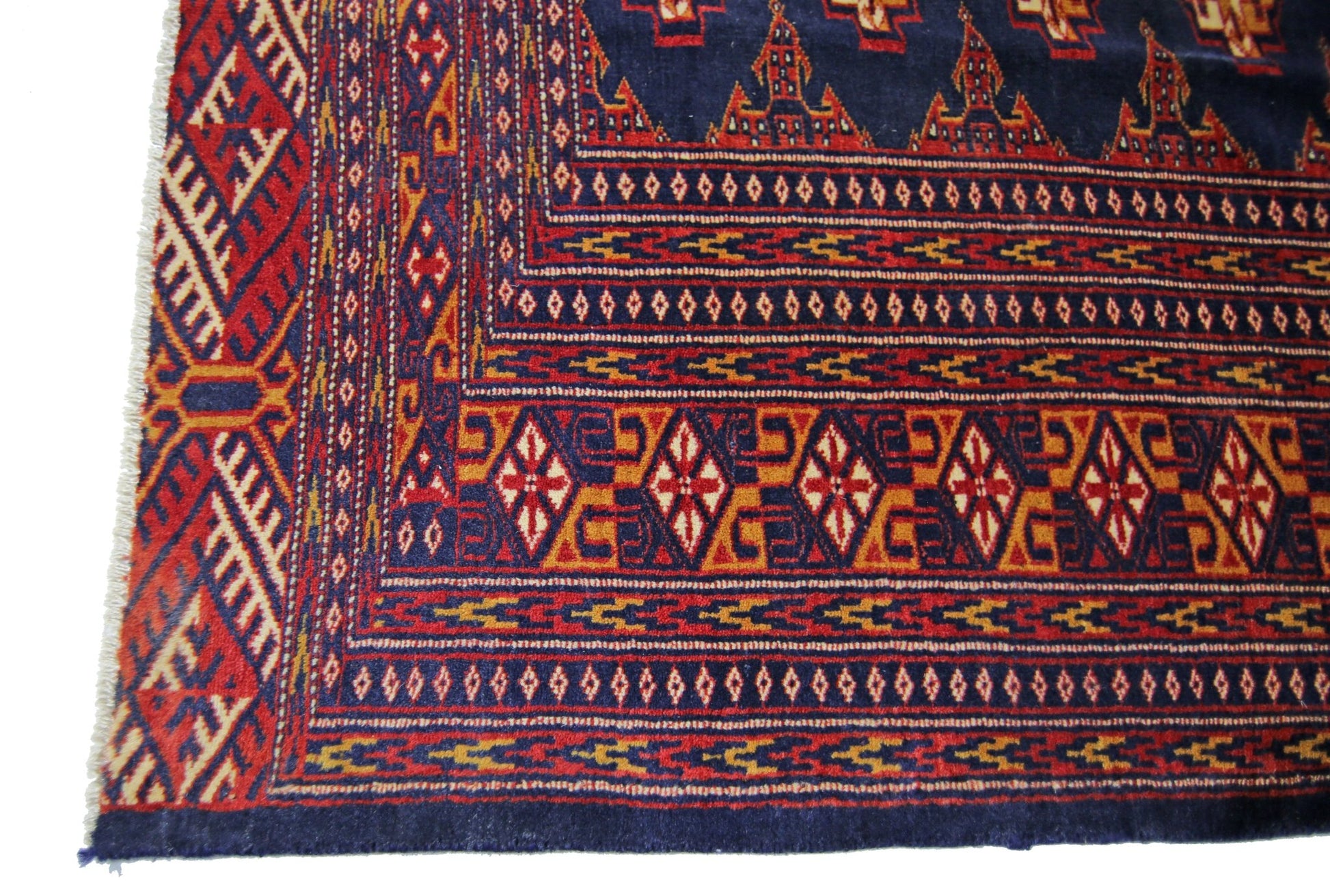 A vintage Pakistani Princess Bokhara rug featuring intricate geometric patterns in red, blue, and gold.