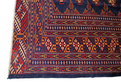 A vintage Pakistani Princess Bokhara rug featuring intricate geometric patterns in red, blue, and gold.