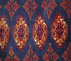 A vintage Pakistani Princess Bokhara rug featuring a repeating geometric pattern on a blue field.