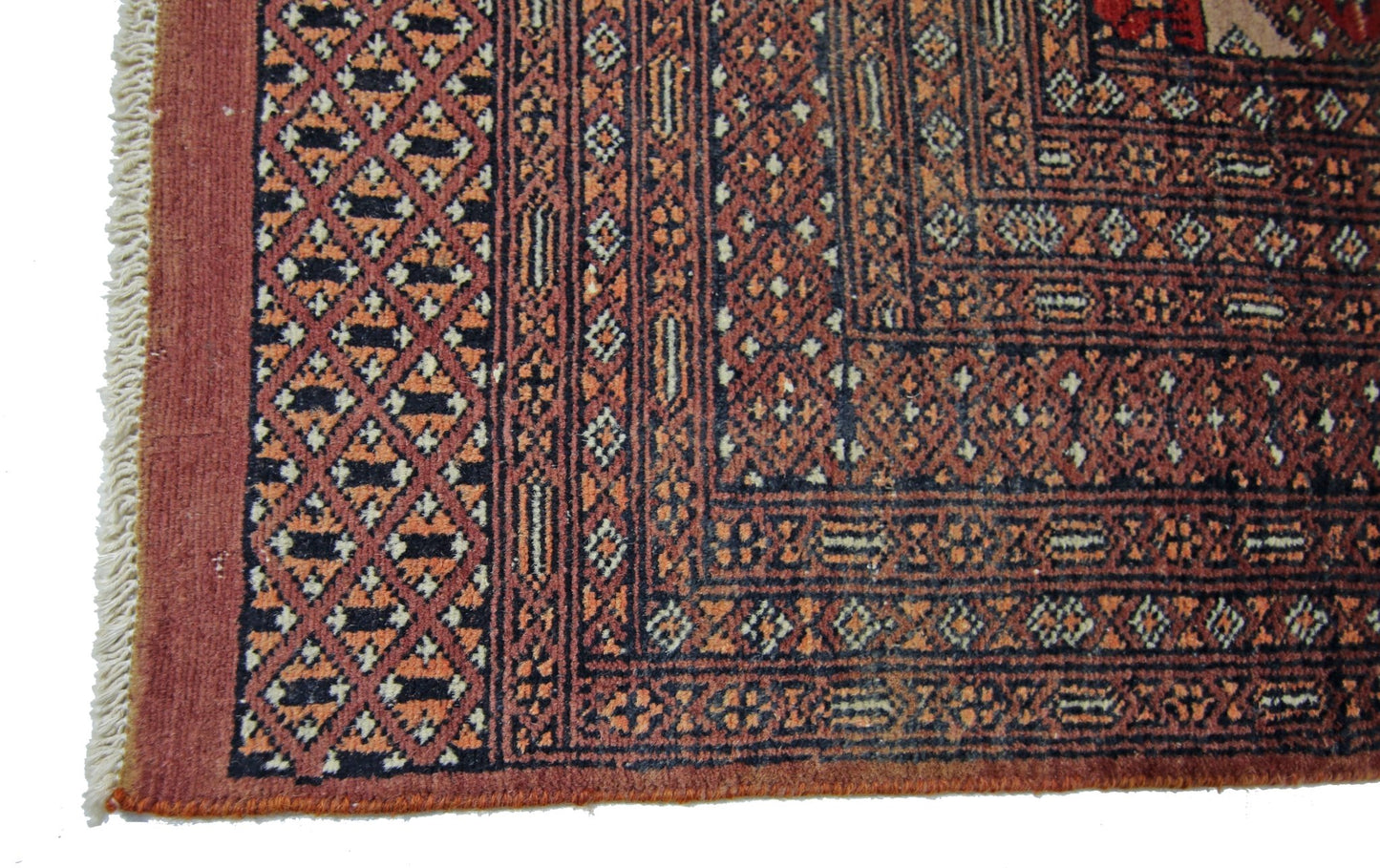 A vintage Pakistani Princess Bokhara rug featuring a geometric diamond pattern in red and black.