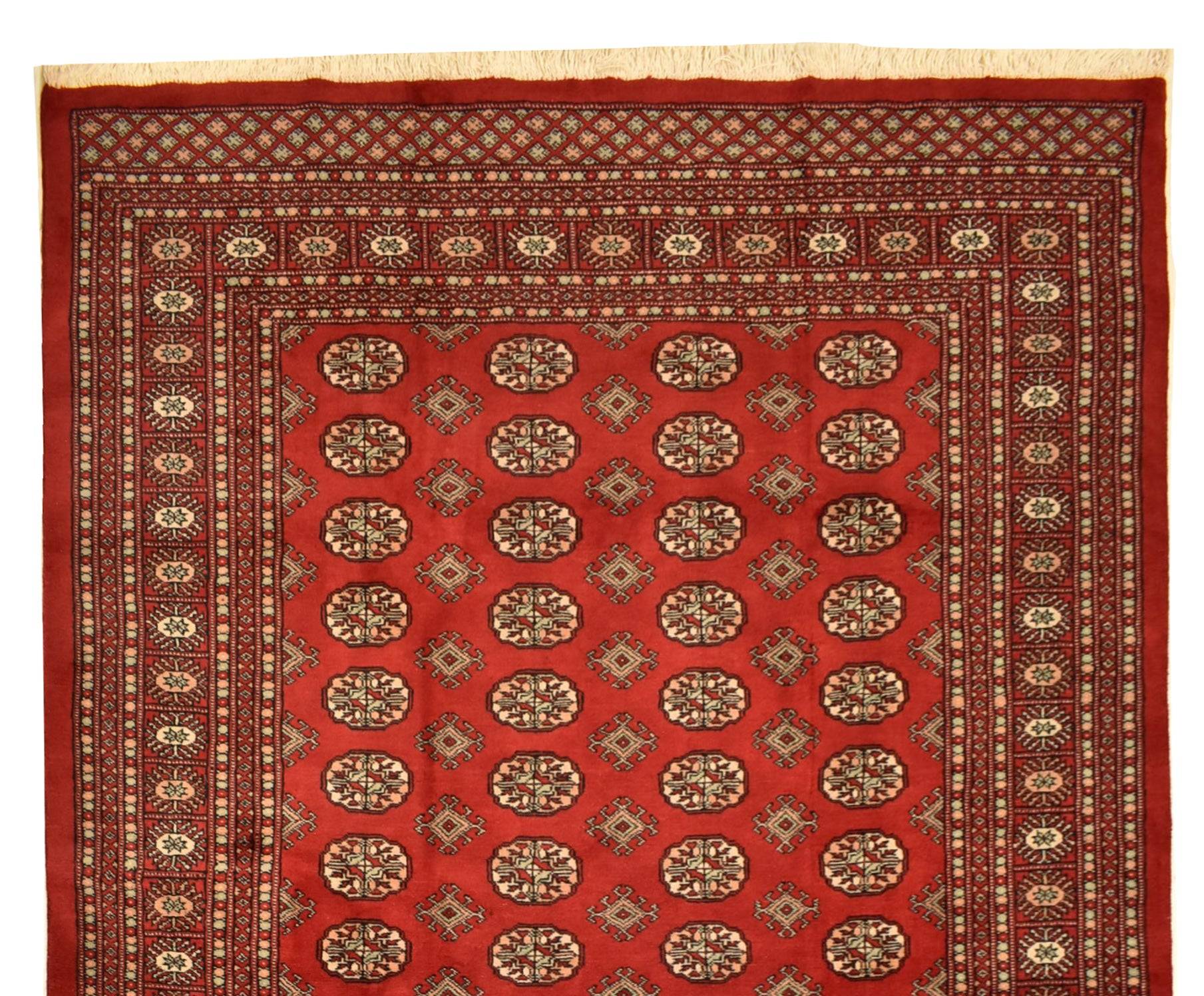 Handmade red wool Princess Bokhara rug featuring repeating geometric elephant foot motifs.