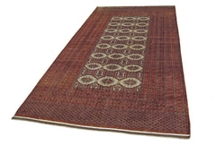 A vintage Pakistani Princess Bokhara rug featuring a repeating octagonal pattern in red and cream.