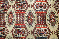 Vintage Pakistani Princess Bokhara rug featuring a repeating geometric pattern in red and cream.