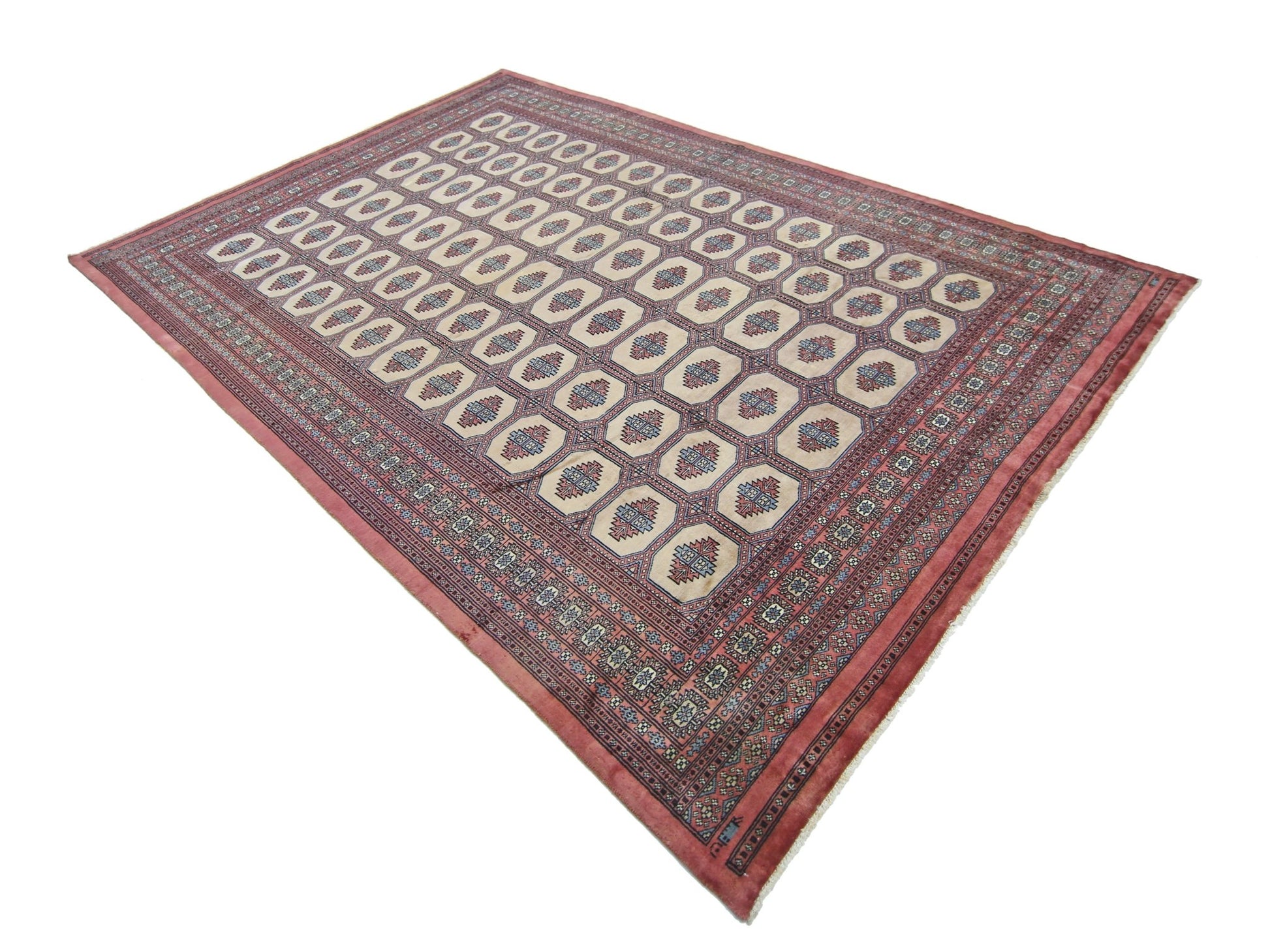 A vintage Pakistani Princess Bokhara rug featuring a repeating geometric pattern on a red field.