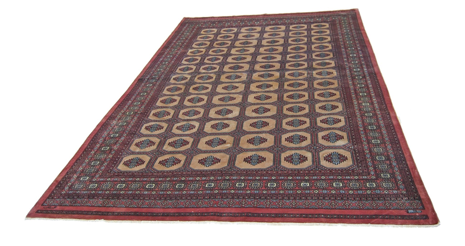A vintage Pakistani Princess Bokhara rug featuring a repeating geometric pattern on a red field.