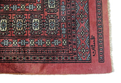 A vintage Pakistani Princess Bokhara rug featuring a geometric pattern in shades of red and blue.