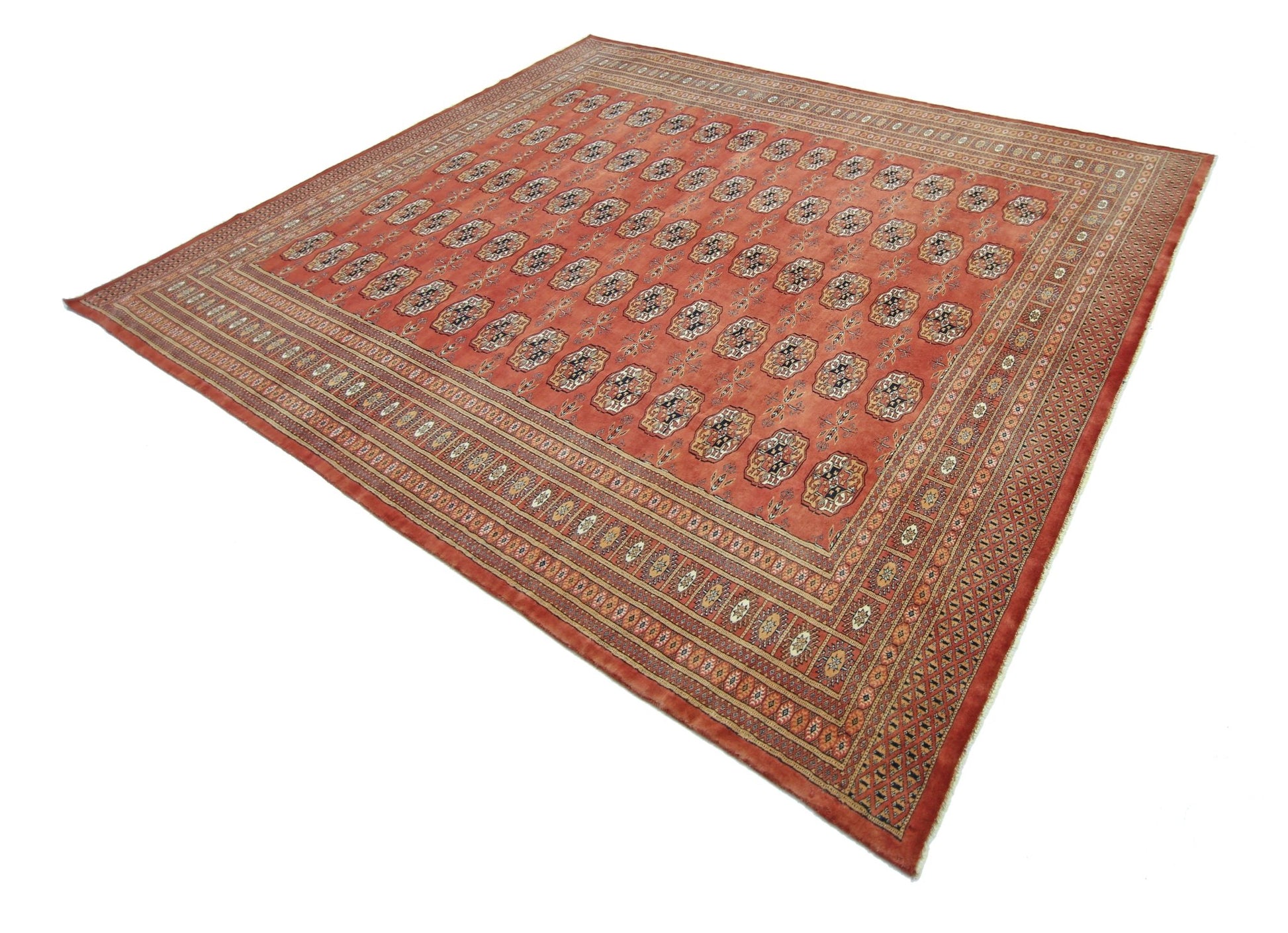 A vintage Pakistani Princess Bokhara rug featuring a repeating geometric pattern on a red field.