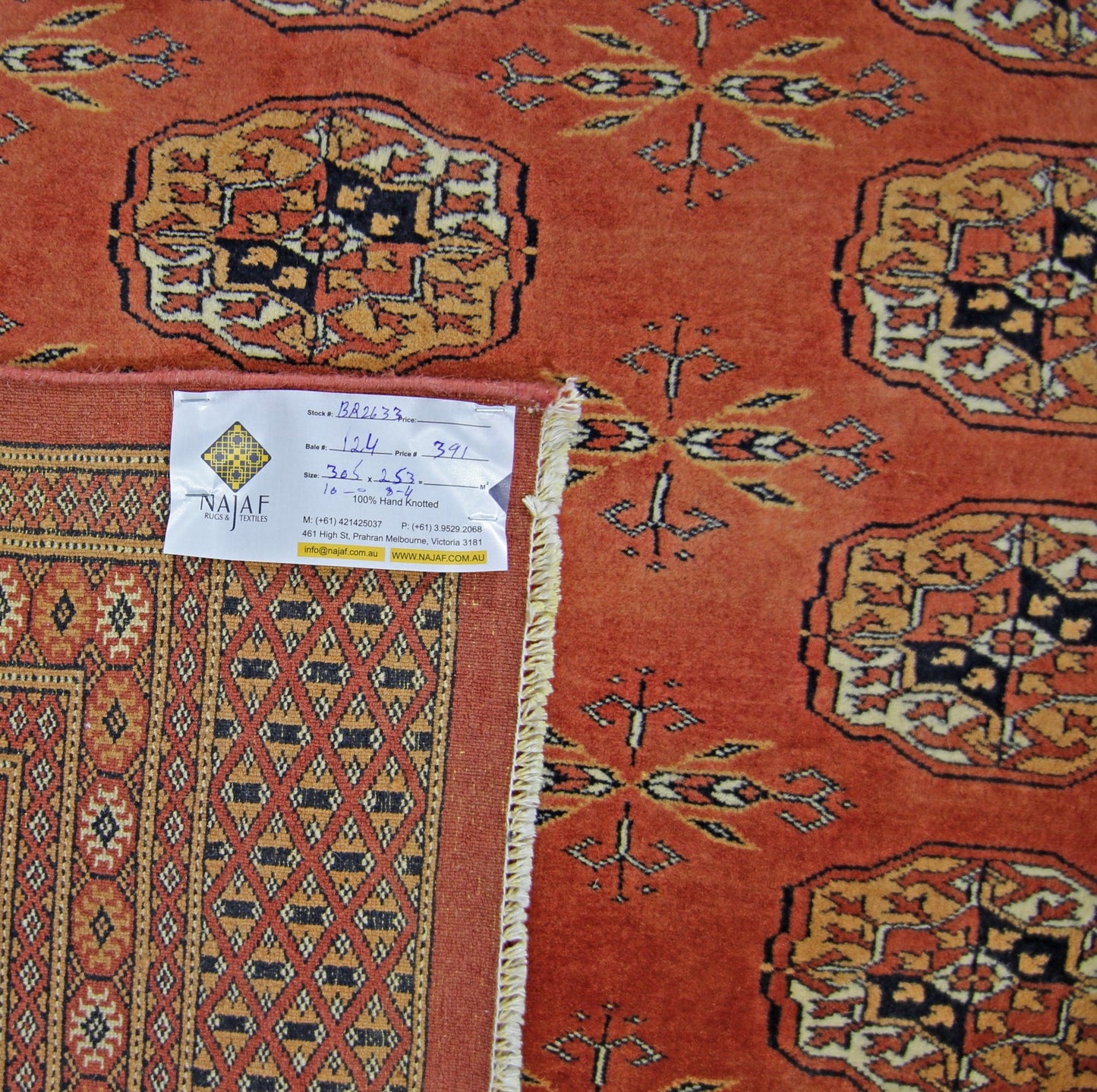 A vintage Pakistani Princess Bokhara rug featuring a repeating geometric pattern in rust red.