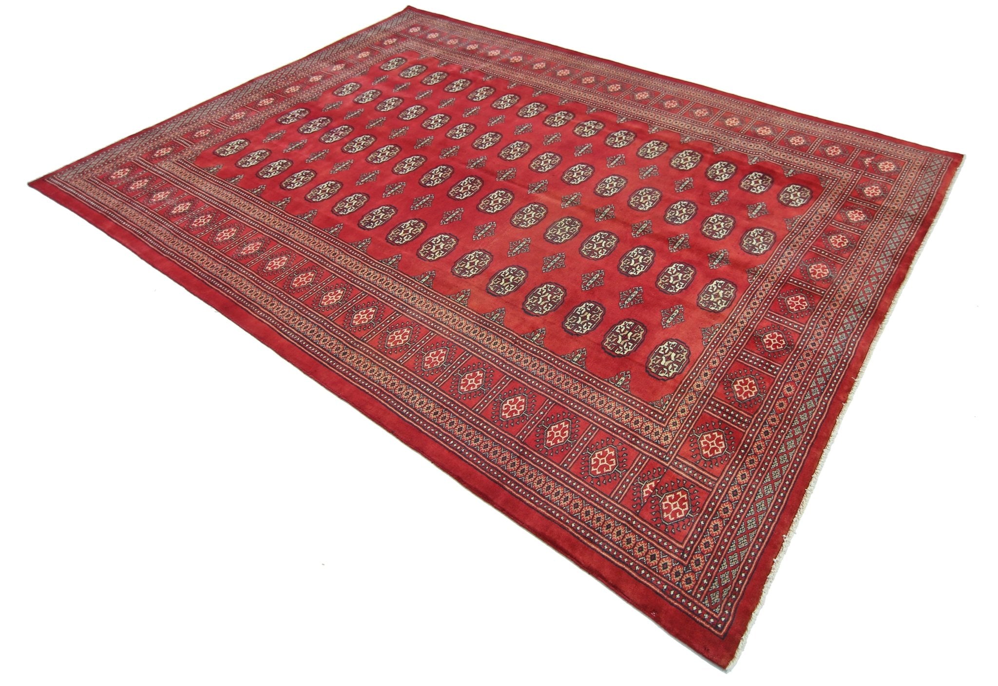 A vintage Pakistani Princess Bokhara rug featuring a repeating geometric pattern on a red field.
