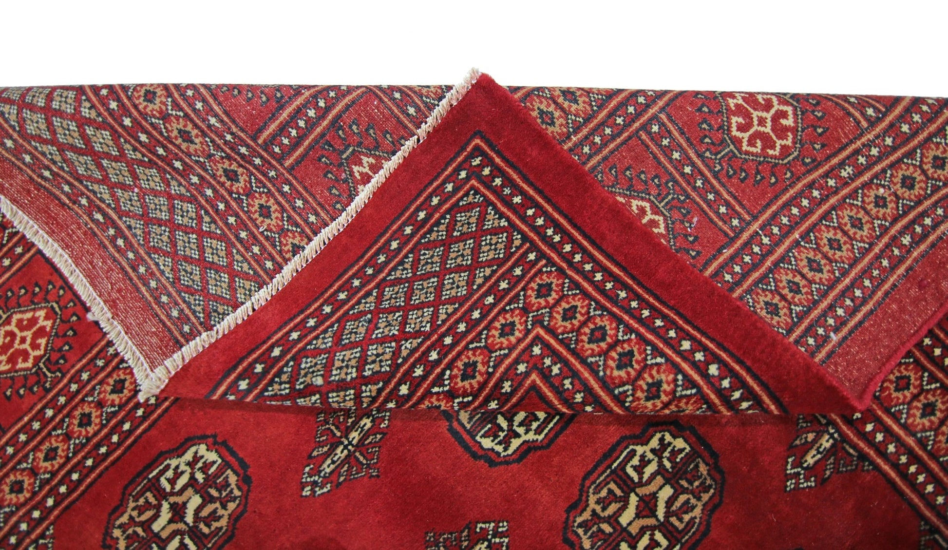 A vintage Pakistani Princess Bokhara rug featuring a deep red field with repeating geometric motifs.