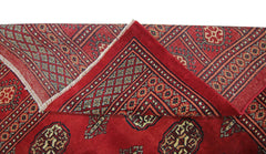 A vintage Pakistani Princess Bokhara rug featuring a deep red field with repeating geometric motifs.