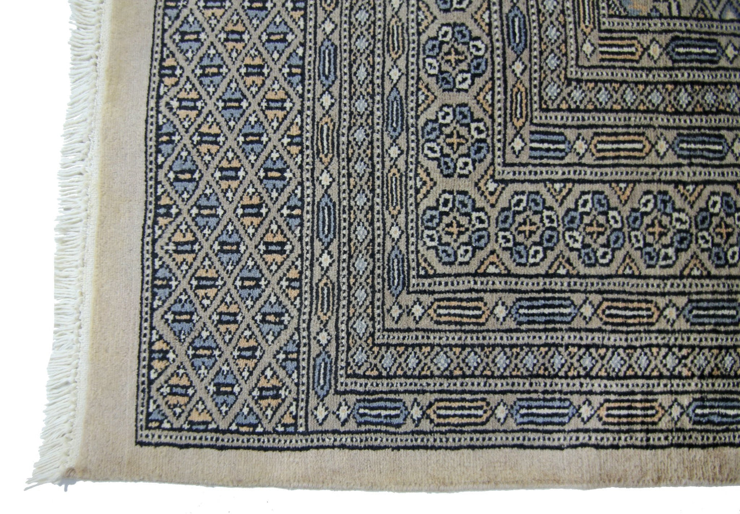 A vintage Pakistani Princess Bokhara rug featuring a geometric diamond pattern in blue and tan.