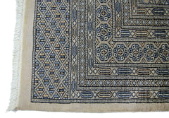 A vintage Pakistani Princess Bokhara rug featuring a geometric diamond pattern in blue and tan.