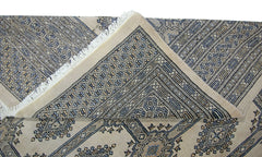 A vintage Pakistani Princess Bokhara rug with a geometric pattern in blue and beige tones.