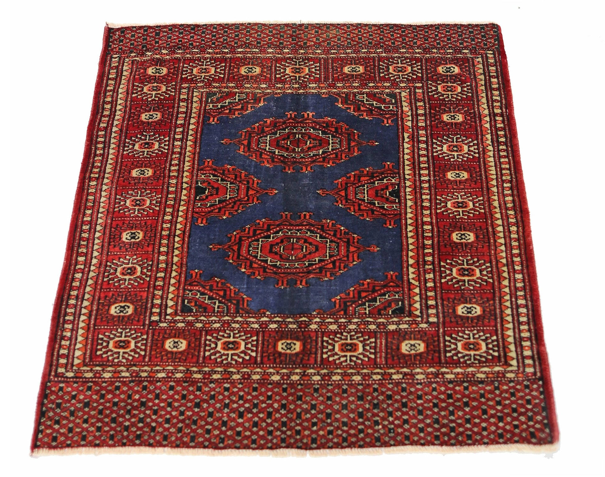 A vintage Pakistani Princess Bokhara rug featuring a blue field with red geometric medallions.