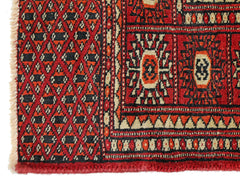 A vintage Pakistani Princess Bokhara rug featuring a geometric diamond pattern in red and black.
