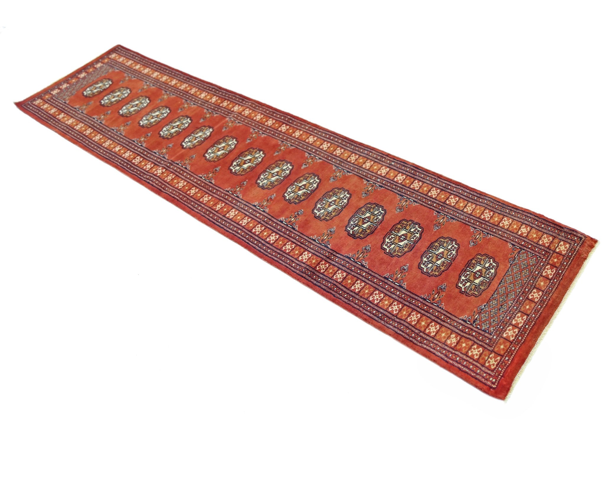 A vintage Pakistani Princess Bokhara runner rug featuring a repeating geometric pattern in red.
