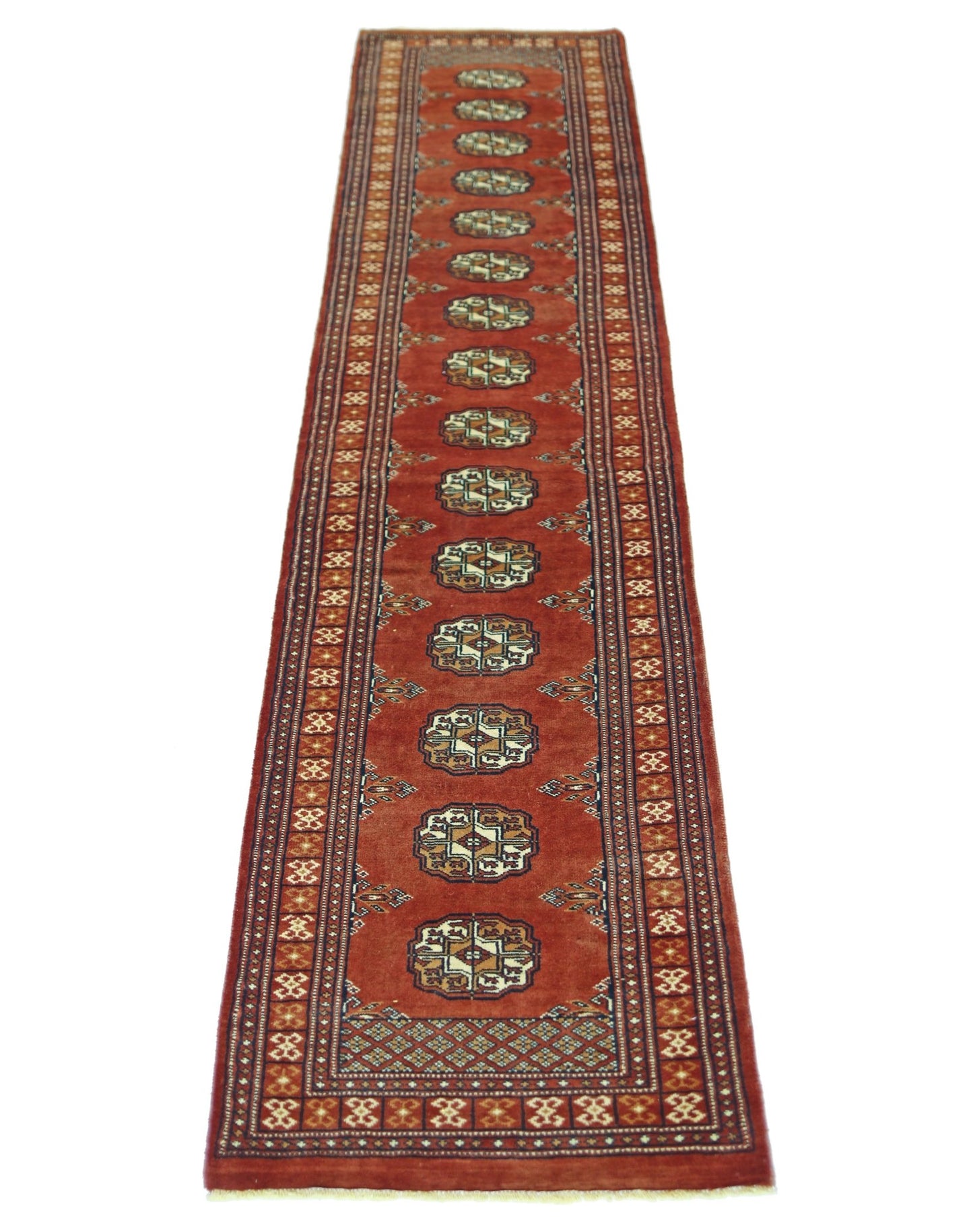 A vintage Pakistani runner rug featuring repeating geometric motifs on a rich red background.