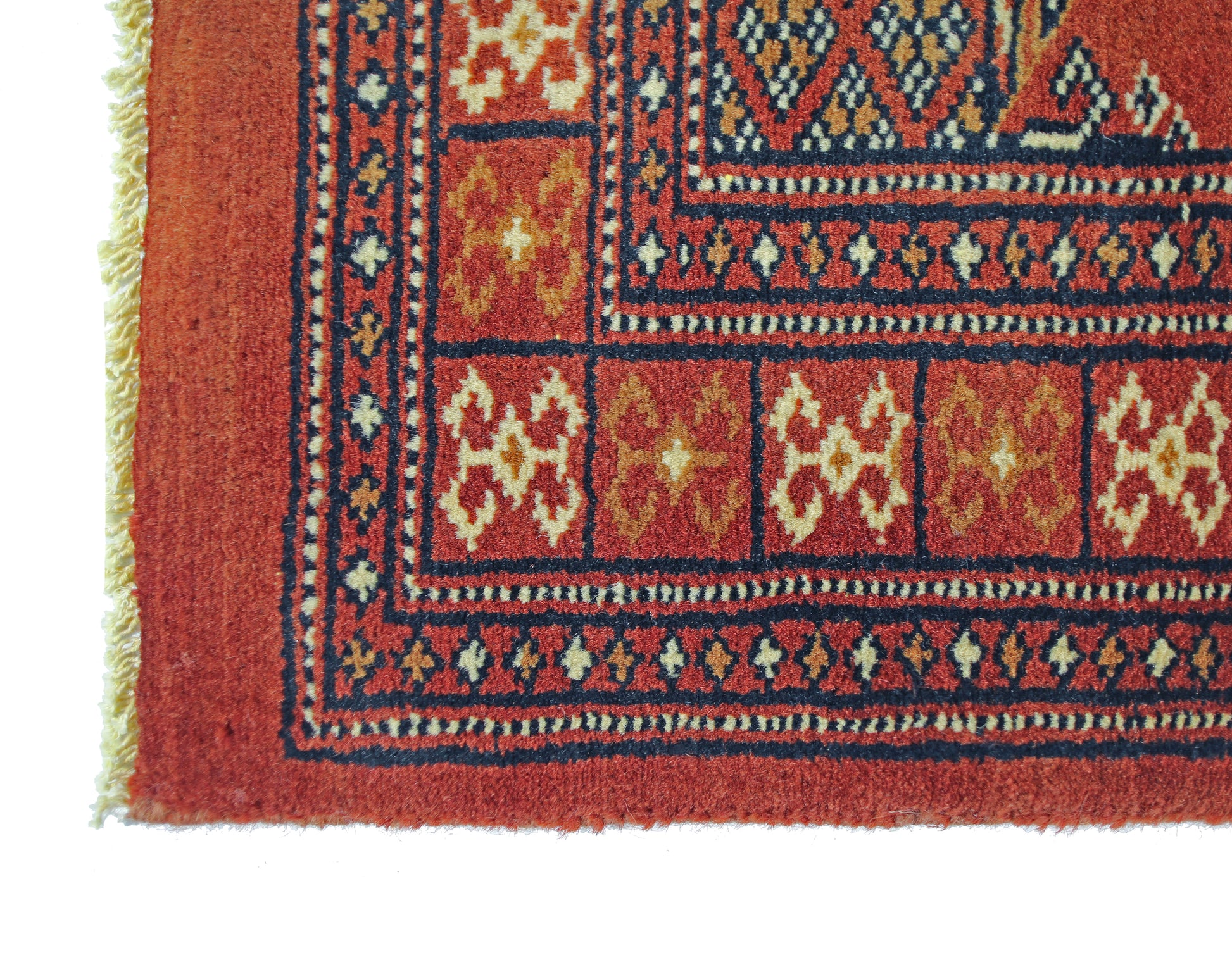 A vintage Pakistani Princess Bokhara runner featuring a geometric red pattern and fringed edges.