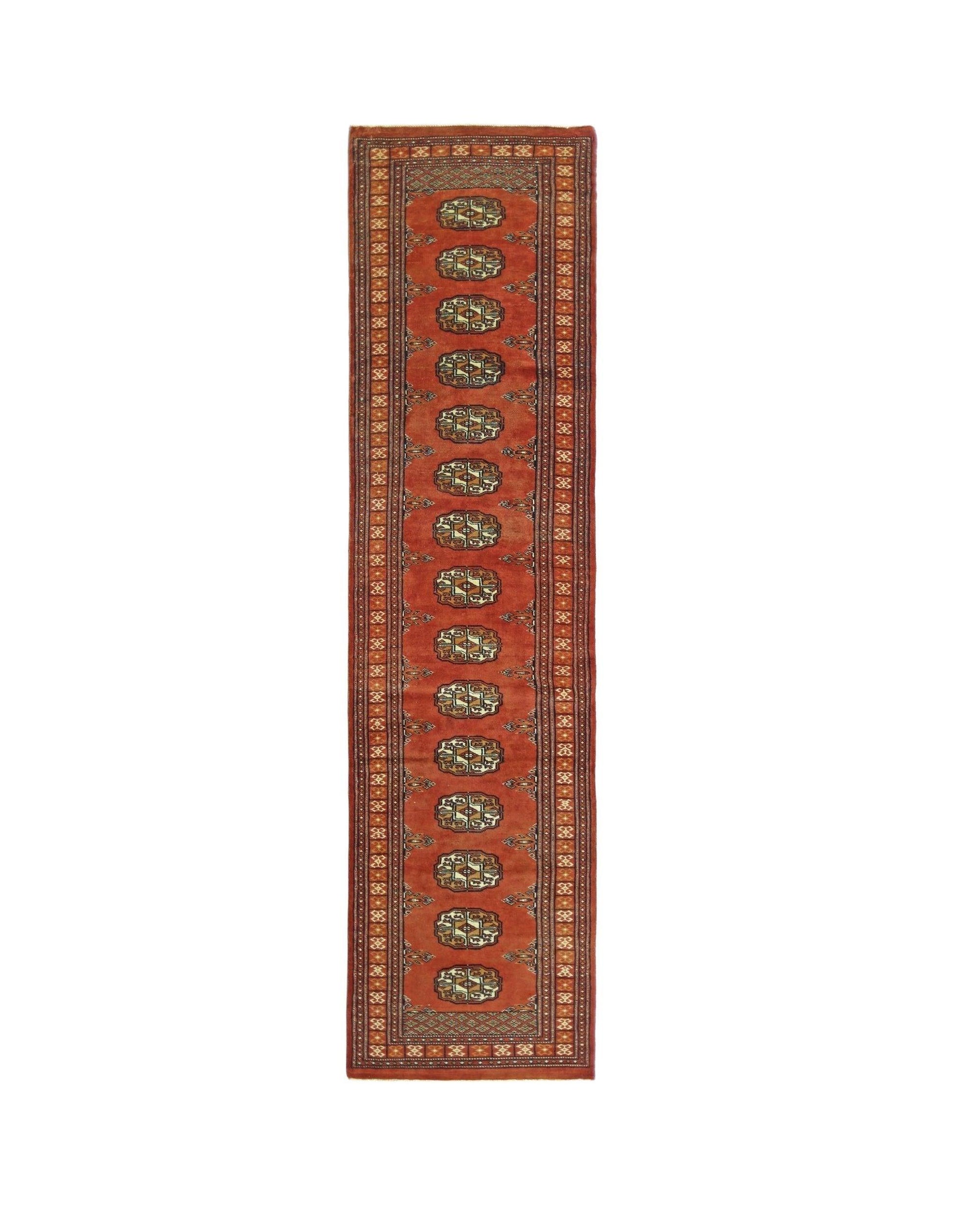 A vintage Pakistani runner rug featuring a repeating geometric pattern on a rich red background.