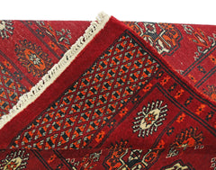 A vintage Pakistani Princess Bokhara runner featuring a red geometric pattern and fringe.
